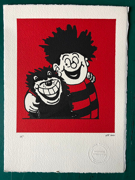 Dennis hugs Gnasher on a red background